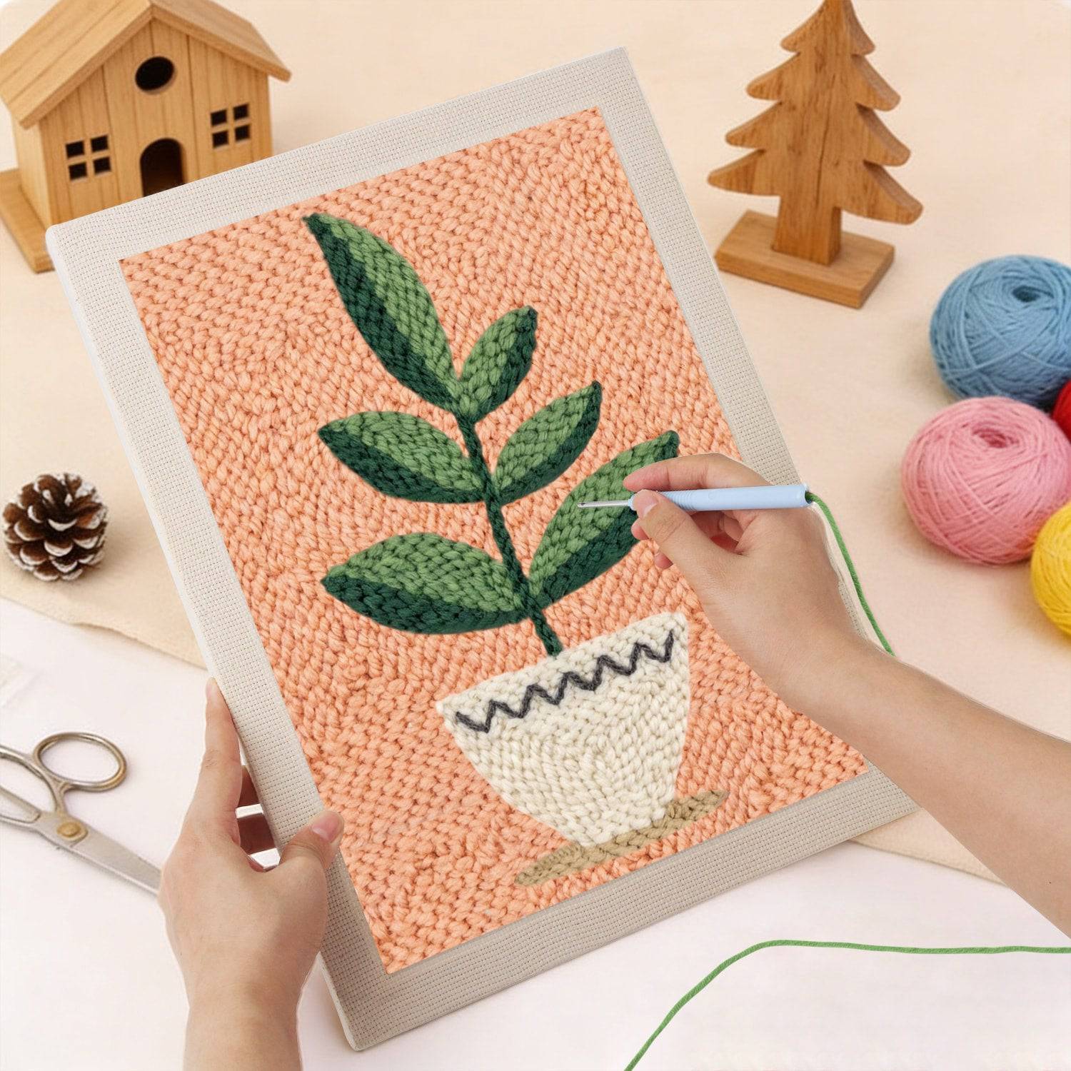 Calm Leaves Punch Needle Kit by HeyHobby featuring colorful yarn and punch needle tools on a wooden surface.