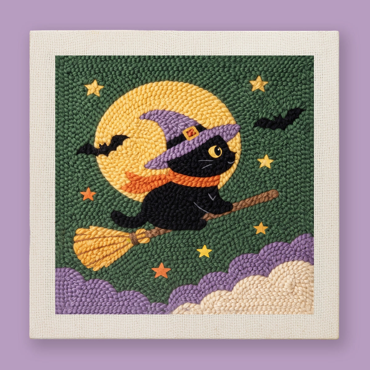 Punch needle wall art of a black witch cat riding a broomstick past a full yellow moon on a forest green background