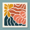 Punch needle wall art kit featuring a sunflower, rose bloom, and teal leaves in mustard yellow, terracotta, and dusty rose