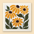Punch needle wall art of four golden black-eyed Susan flowers with olive green leaves on a cream background