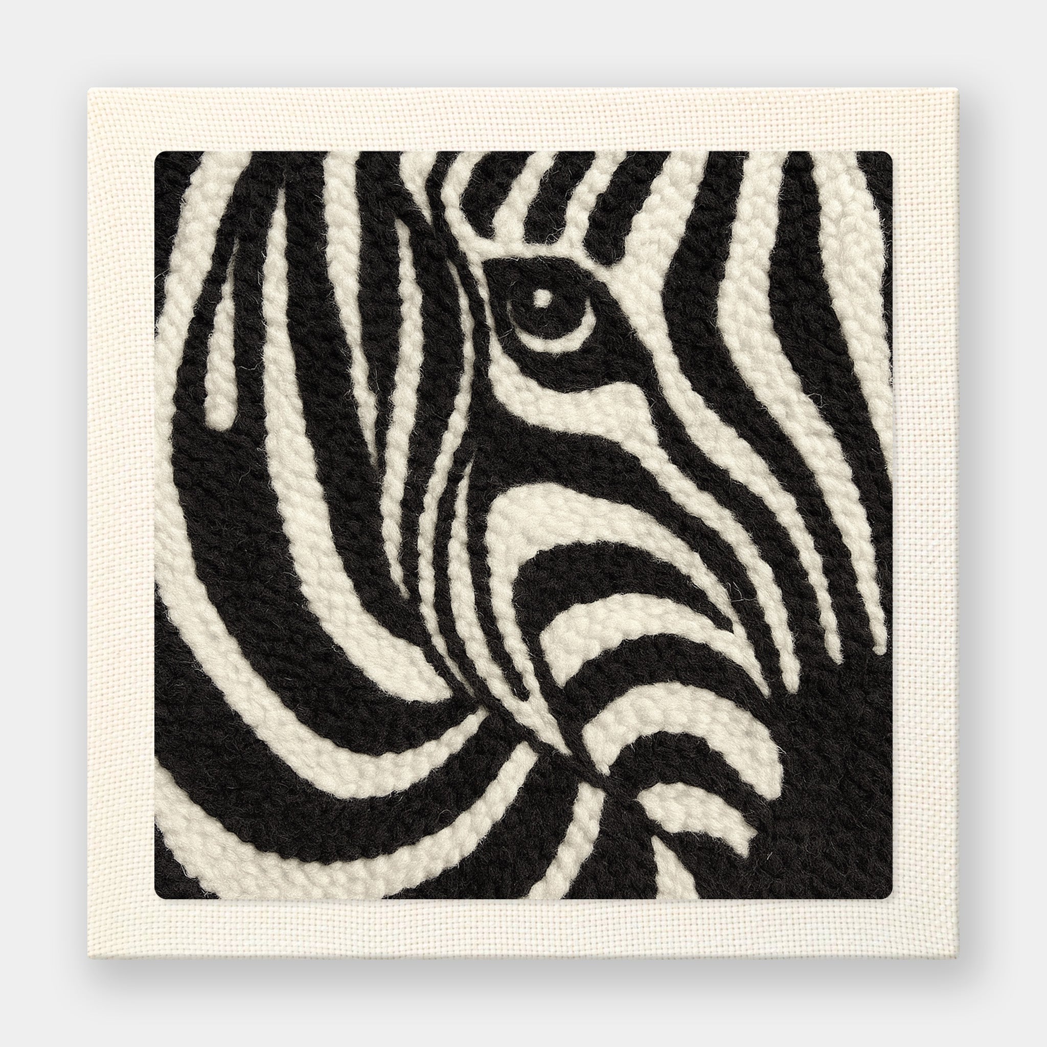 Bold black and white punch needle art featuring a close-up zebra portrait with striking stripe patterns