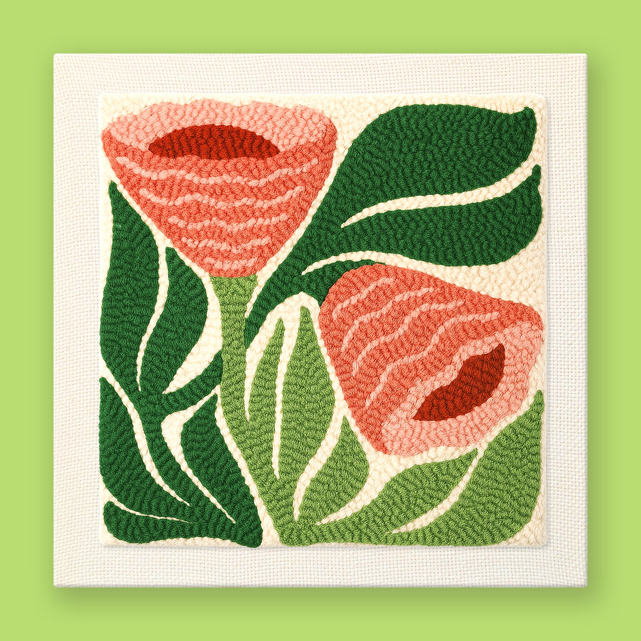 Punch needle wall art featuring coral tropical flowers and green monstera leaves on a framed canvas