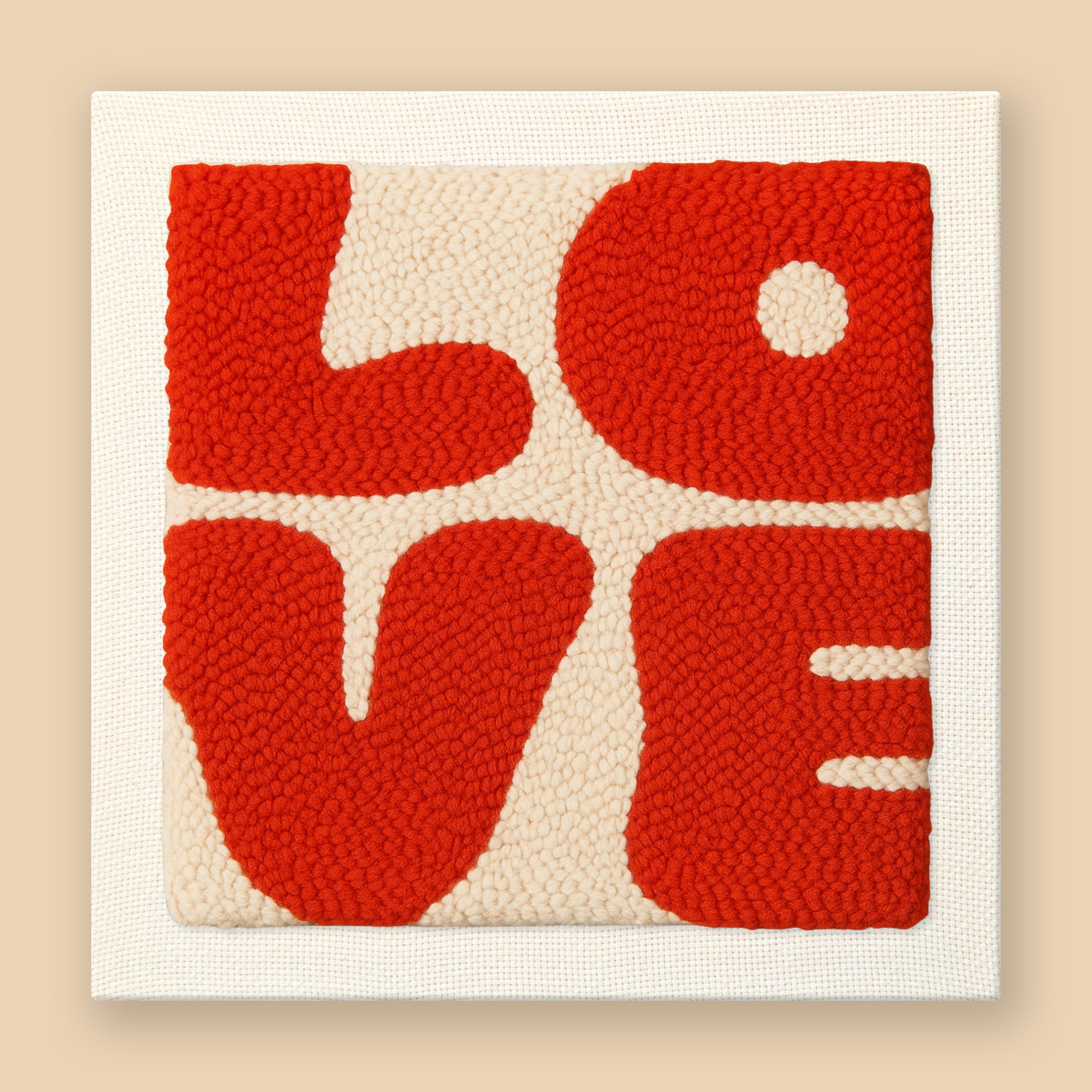 Modern punch needle wall art spelling LOVE in bold graphic letters with red and cream colors